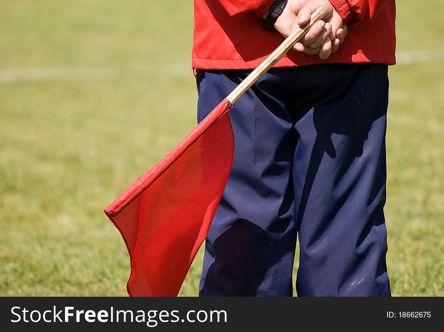 Soccer judge with red flag for back