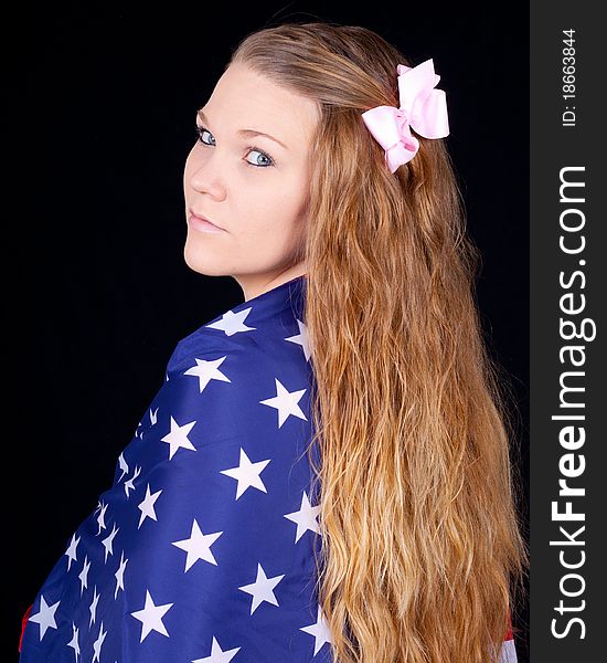 A cute girl with an American Flag wrapped around her. A cute girl with an American Flag wrapped around her.