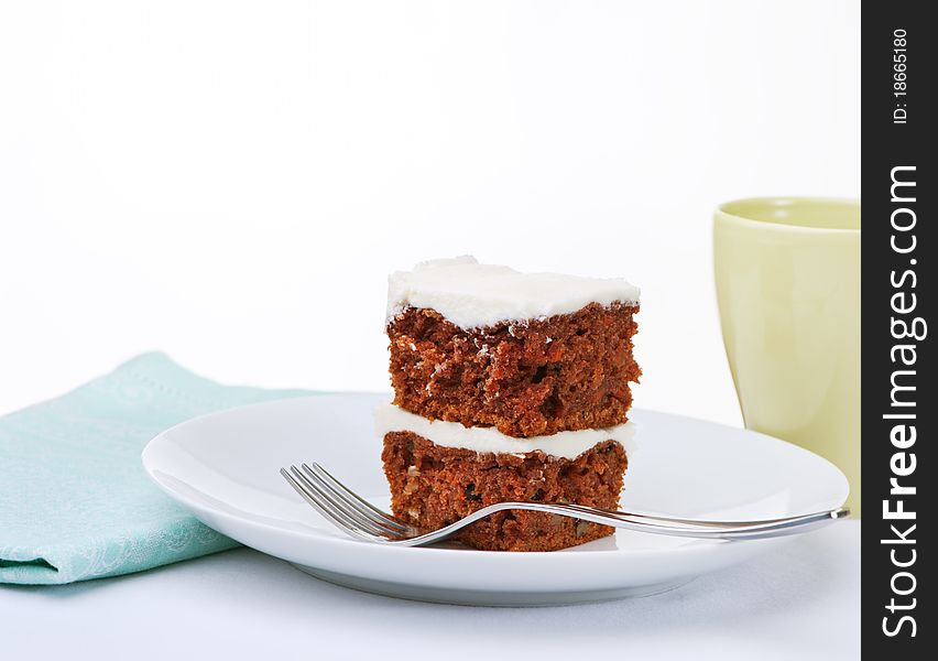 Carrot cake with butter cream frosting on white plate. Carrot cake with butter cream frosting on white plate