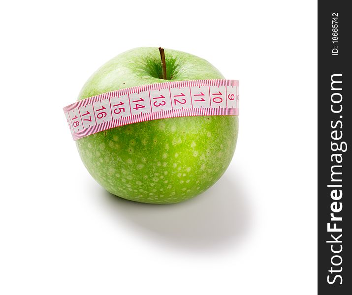 Green apple and measuring tape of the tailor isolated on white