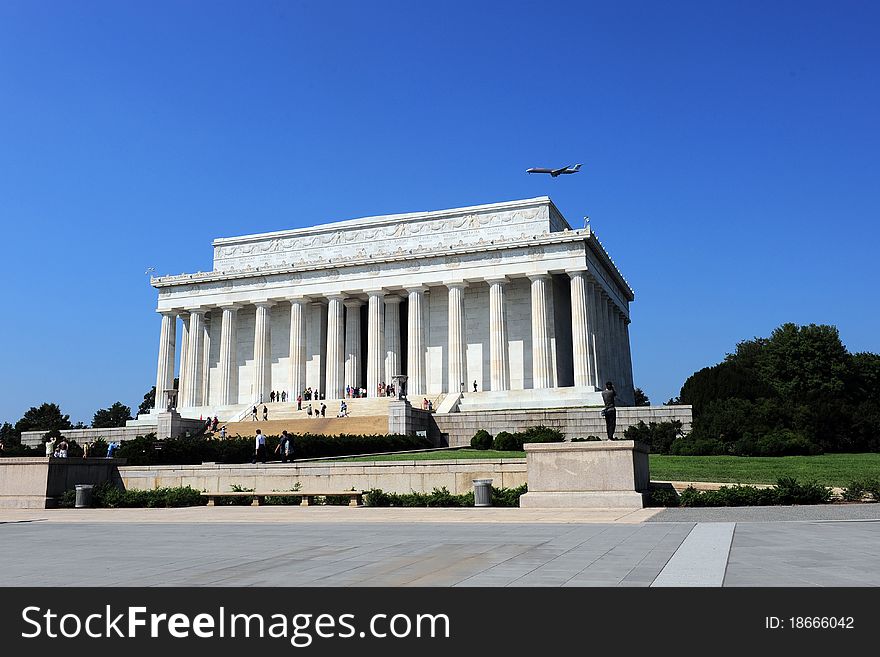 An airplane flying over the Lincoln Memorial in a clear, deep blue sky. An airplane flying over the Lincoln Memorial in a clear, deep blue sky.