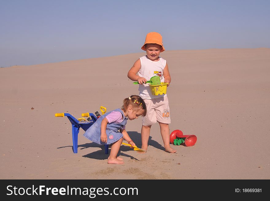 Children play in sand with toys