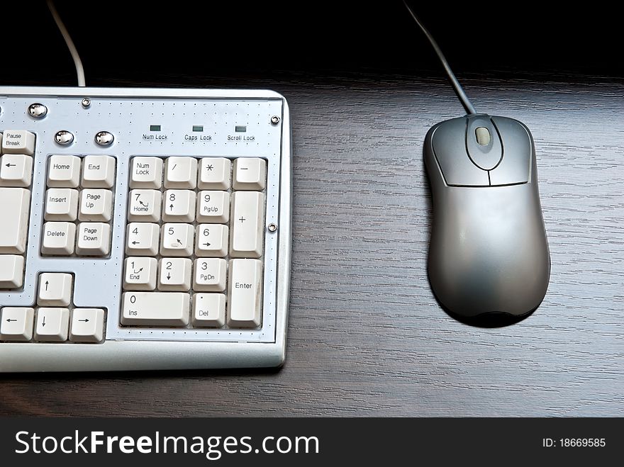 White keyboard and silver mouse on a desk. White keyboard and silver mouse on a desk.