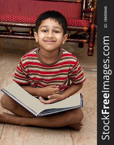 An handsome Indian kid doing his homework very happily