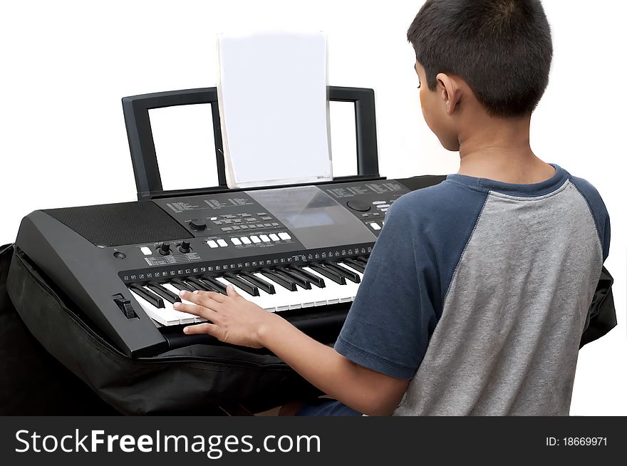 An handsome Indian boy learning music with an electric piano