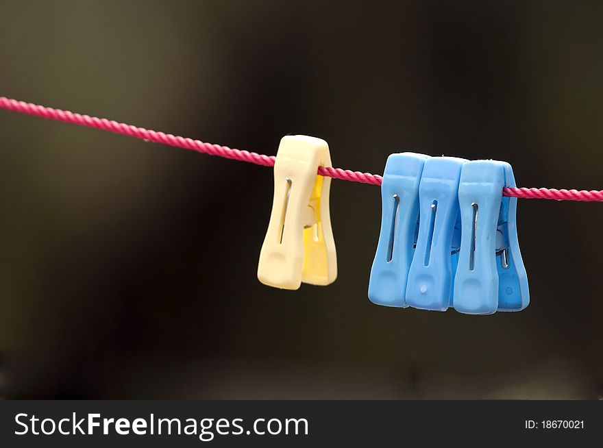 Colorful clip hanging on a cord used for drying cloths