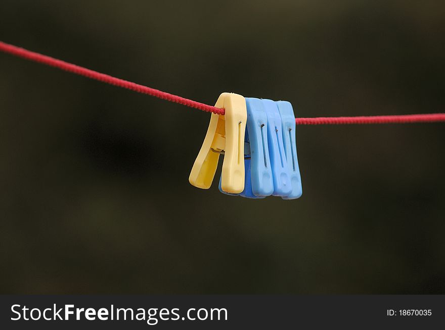 Colorful clip hanging on a cord used for drying cloths