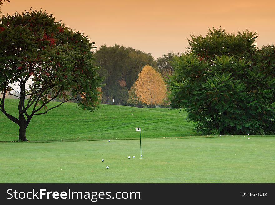 Golf meadow with green grass and smokie sky