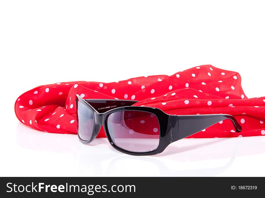 Sunglasses decorated on a red dotted shawl isolated over white. Sunglasses decorated on a red dotted shawl isolated over white