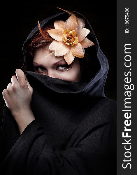 Portrait of woman in black hood with flower. Portrait of woman in black hood with flower