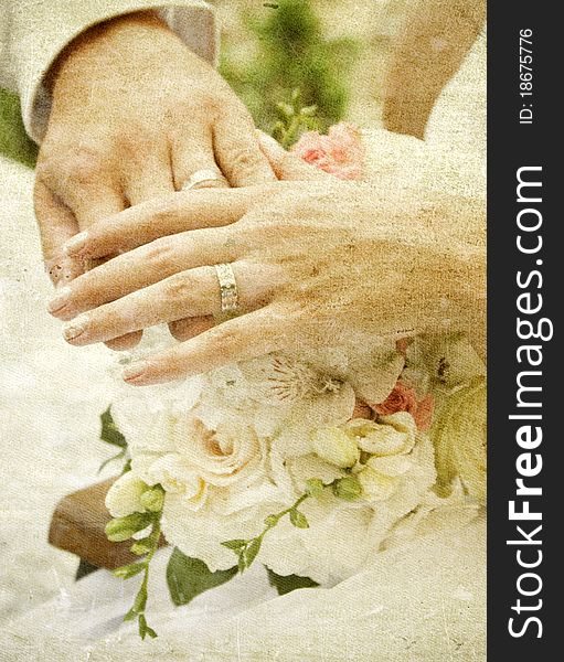 Vintage photo of hands and rings on wedding bouquet