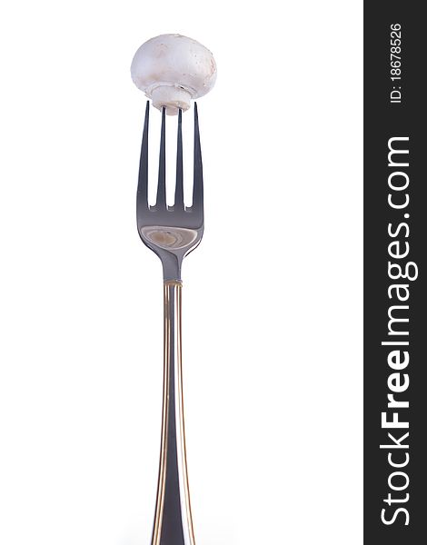 Whole white mushroom on a fork