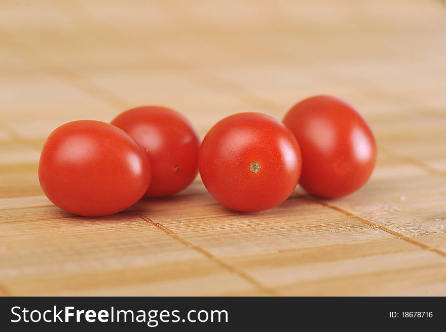 Four ripe and juicy cherry tomatoes on bamboo napkin