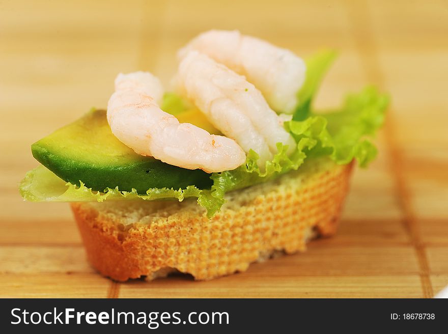 Sandwich garnish with shrimps, avokado and lettuce on bamboo napkin, snack. Sandwich garnish with shrimps, avokado and lettuce on bamboo napkin, snack