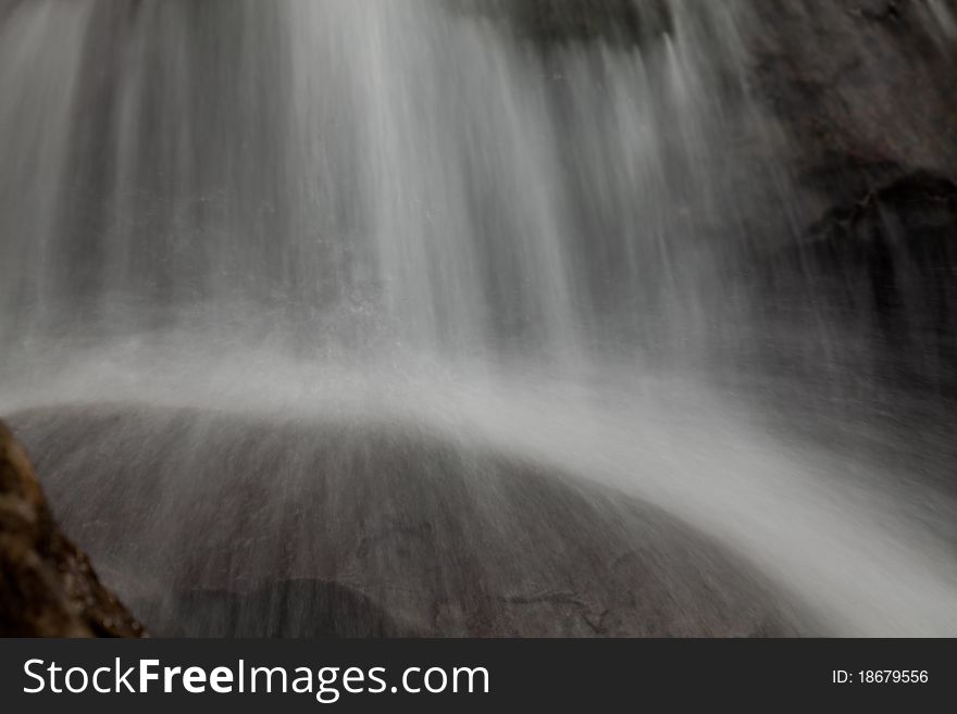 Cascade falls over old plum river with rocks for background or other purpose use