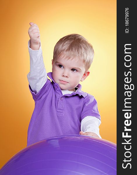 Young blonde boy showing ok sign near the ball. Young blonde boy showing ok sign near the ball