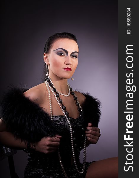 Young woman in fur boa with pearl beads retro syle