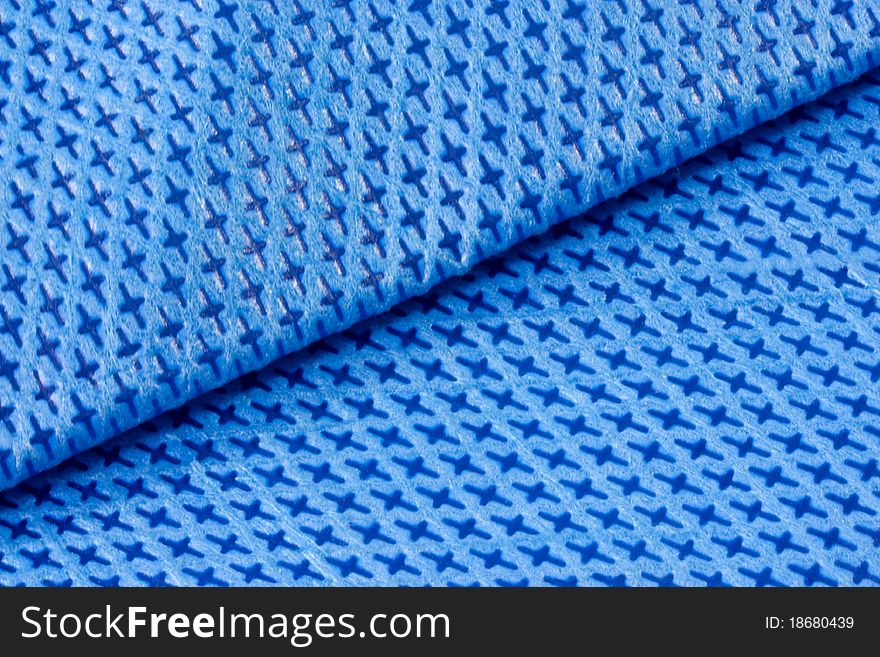 A background of a close up of folded blue nylon fabric. A background of a close up of folded blue nylon fabric