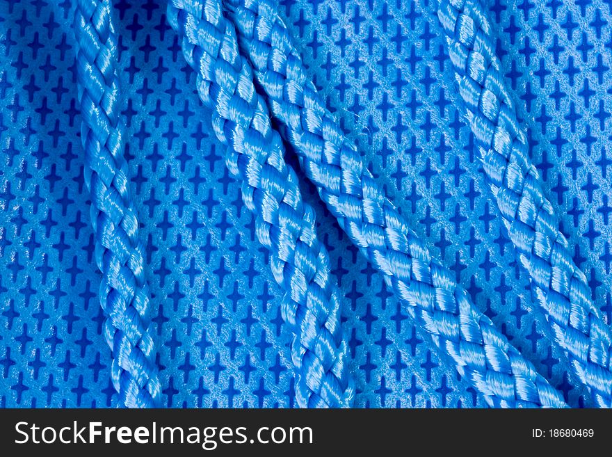 A background of a closeup of blue nylon fabric and shiny blue rope. A background of a closeup of blue nylon fabric and shiny blue rope
