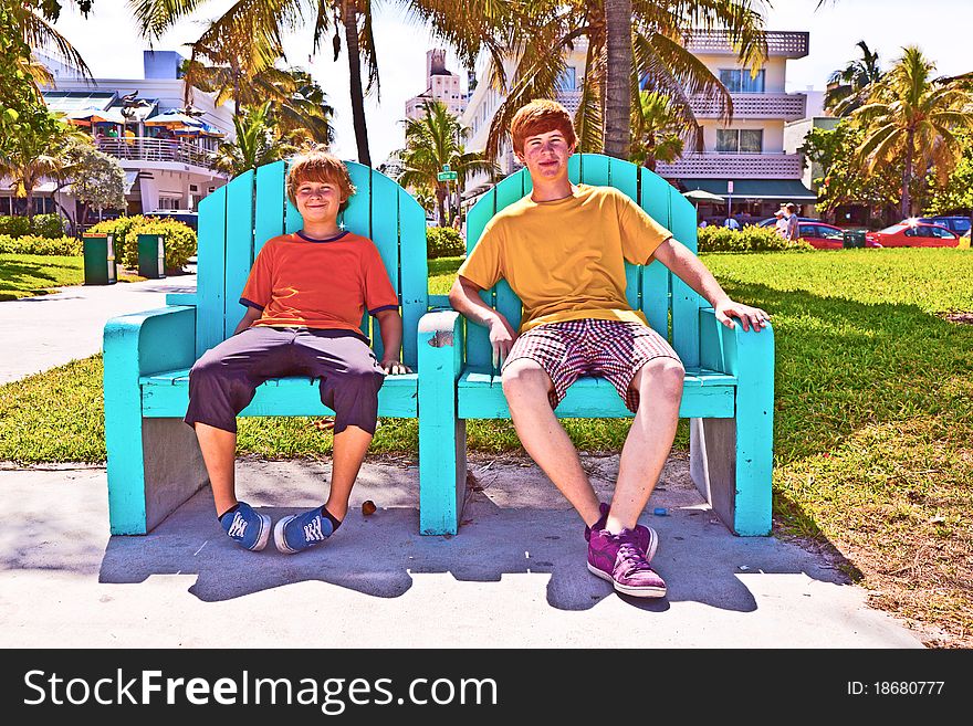 Two Brothers Are Sitting On A Art Deco Park Bench