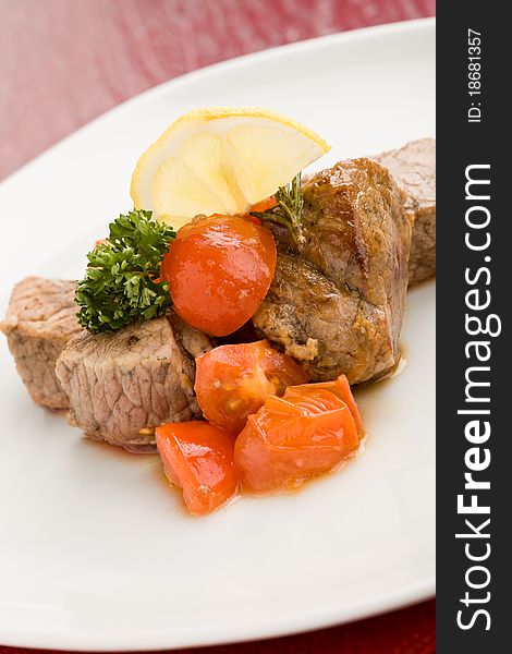 Photo of delicious meat with fresh tomatoes lemon and parsley