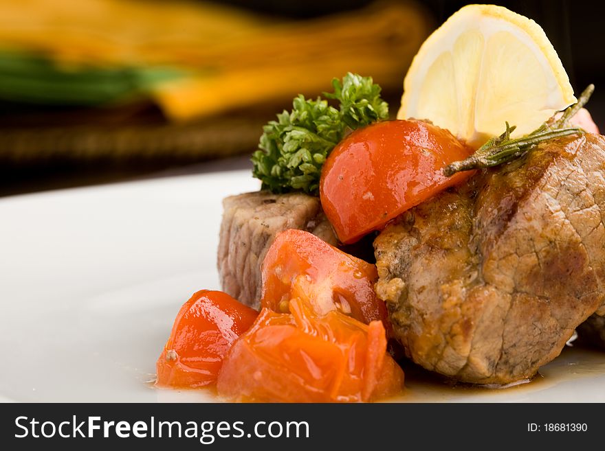 Photo of delicious meat with fresh tomatoes lemon and parsley