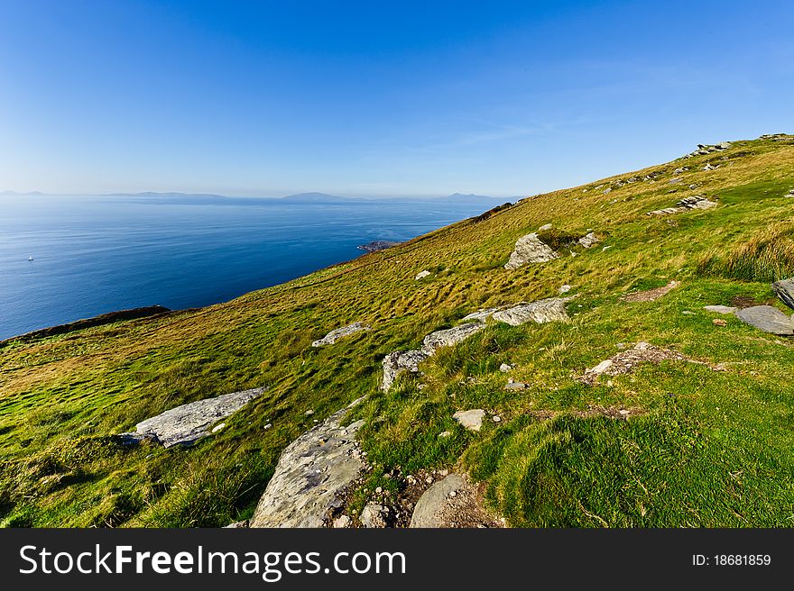 Green meadow by sea under blue sky, Ireland. Green meadow by sea under blue sky, Ireland