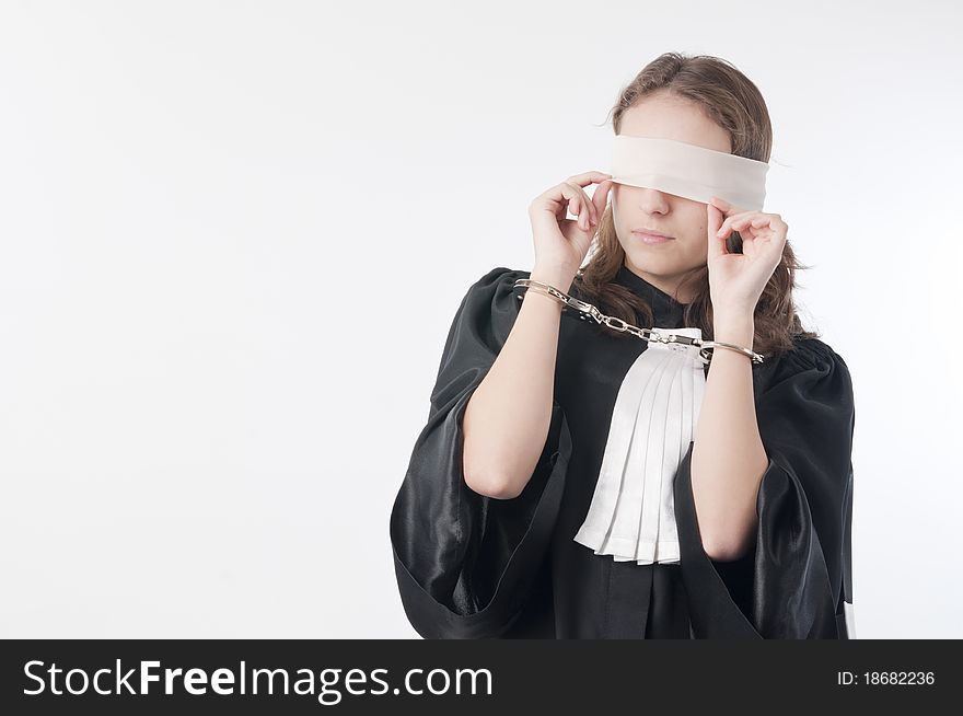 Young law school student holding statute books blindfolded and handcuffed. Young law school student holding statute books blindfolded and handcuffed