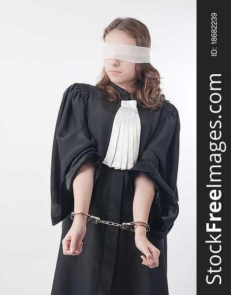 Young law school student holding statute books blindfolded and handcuffed. Young law school student holding statute books blindfolded and handcuffed