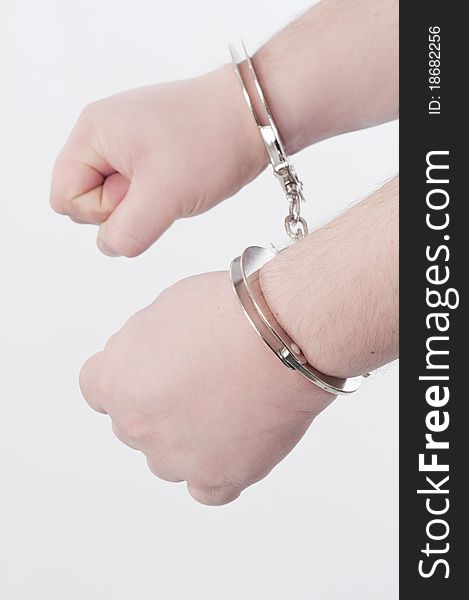 Handcuffed adult man hands; shooted in studio. Handcuffed adult man hands; shooted in studio