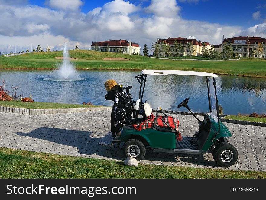 Golf cart on parking over great fields.