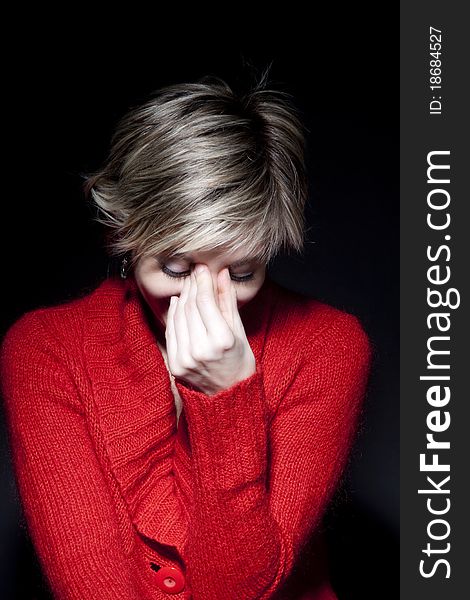 Portrait of attractive woman in red pullover on black background