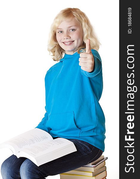Happy schoolgirl sitting on school books showing thumb up. Isolated on white background. Happy schoolgirl sitting on school books showing thumb up. Isolated on white background.