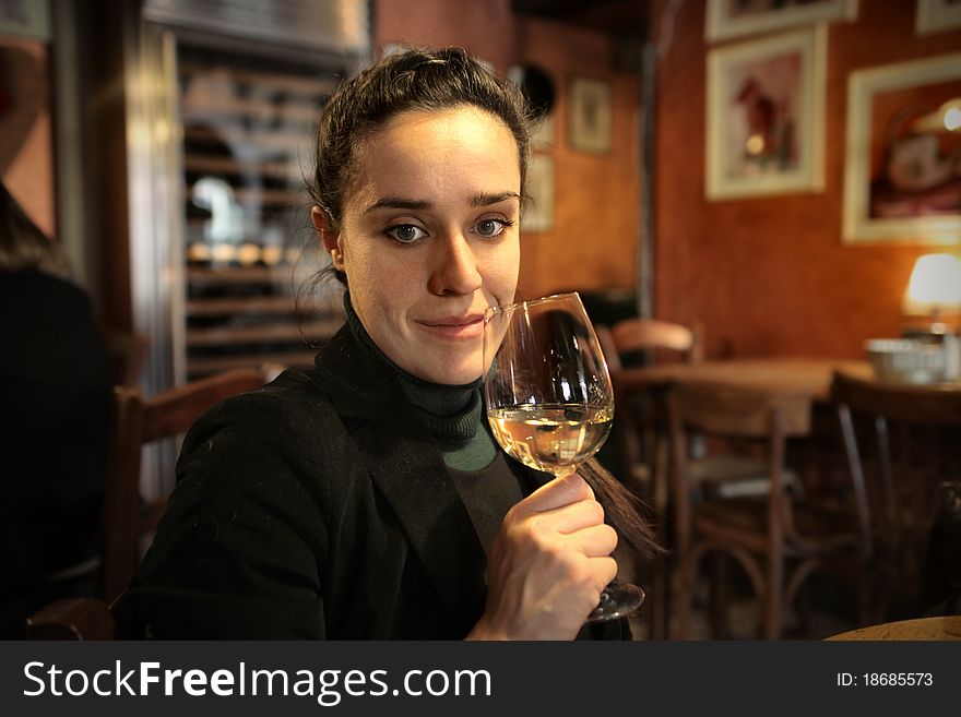 Beautiful woman drinking a glass of wine in a bar