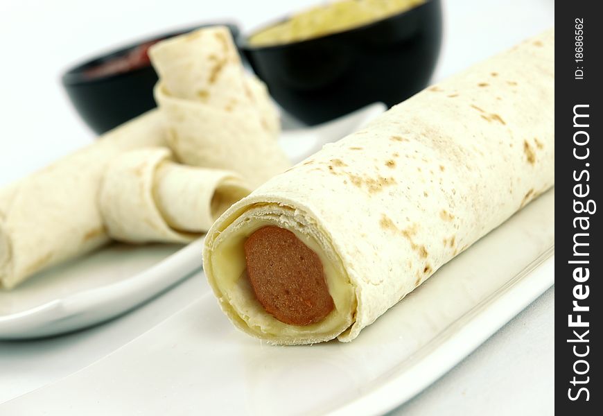 Tortilla wrap with sausage on a plate. Tortilla wrap with sausage on a plate