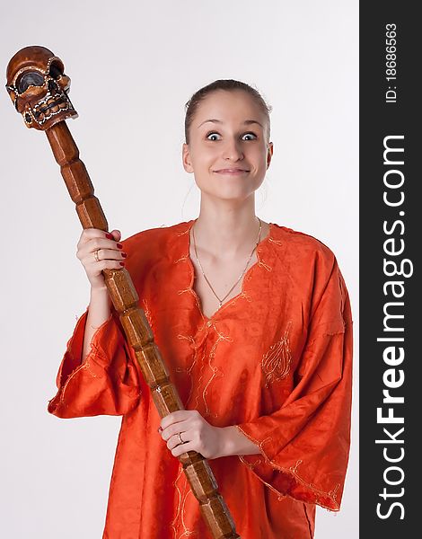 Girl in orange dress on a light background with a staff. Girl in orange dress on a light background with a staff