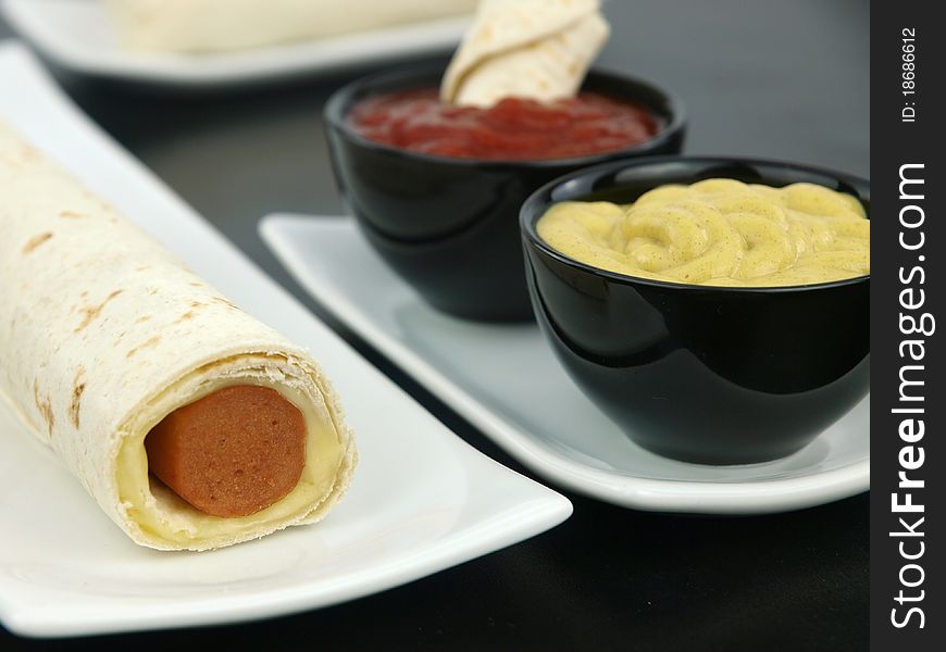 Tortilla wrap with sausage on a plate. Tortilla wrap with sausage on a plate