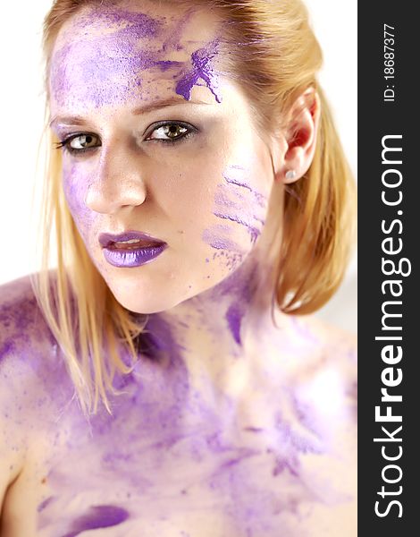 Concept studio portrait of a young woman smeared in purple ink on white. Concept studio portrait of a young woman smeared in purple ink on white