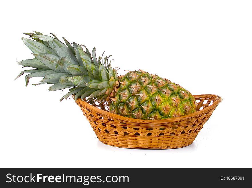Fresh ananas in a wicker basket isolated on a white background