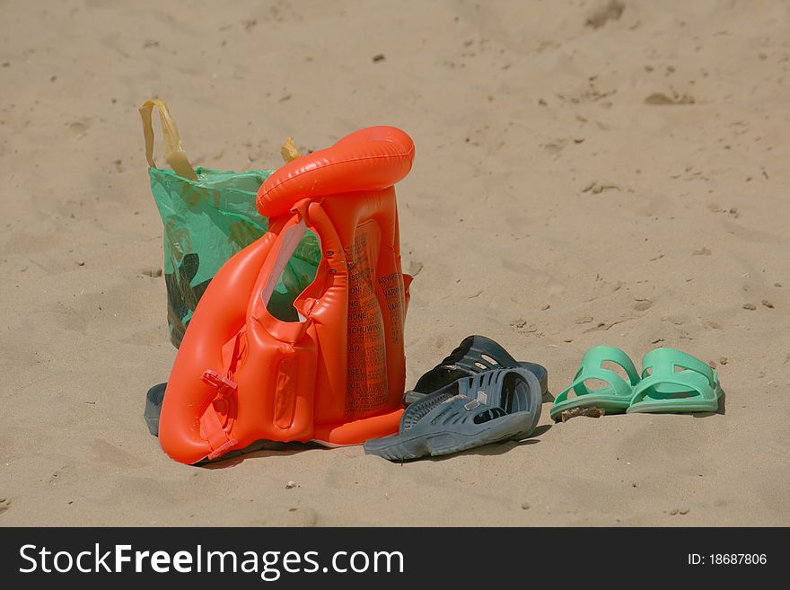Beach set. Sandals, bag, inflatable jacket on sand. Beach set. Sandals, bag, inflatable jacket on sand.