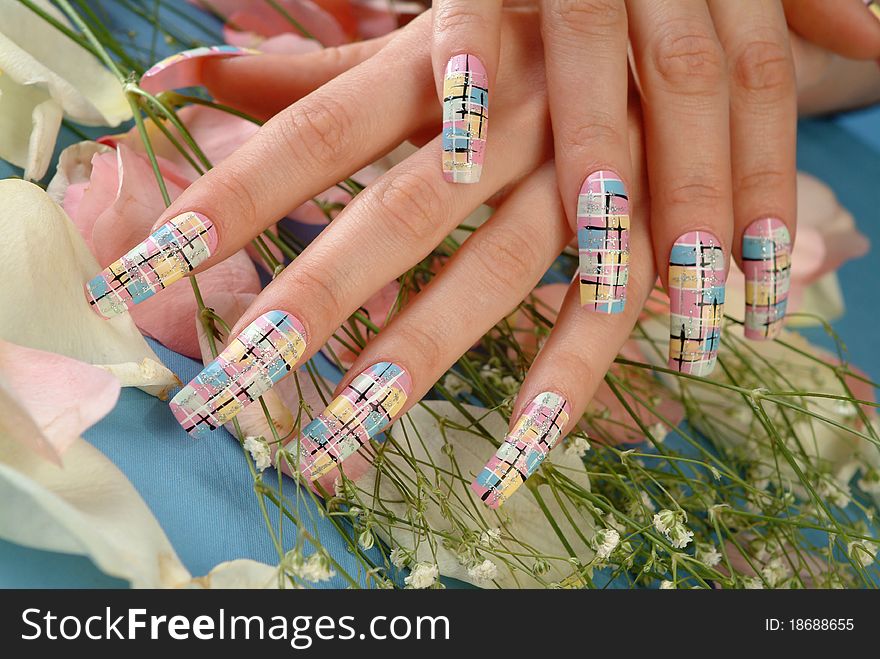 Woman's hand with colored nail polish on the bouquet of flowers
