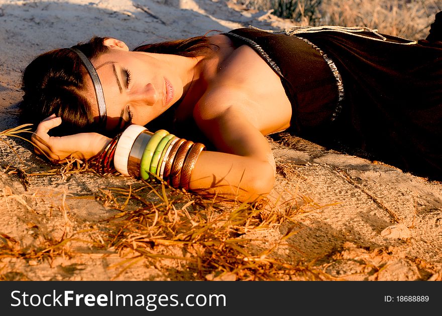 Girl laying on the sandy beach with fashionable summer chlotes. Girl laying on the sandy beach with fashionable summer chlotes.