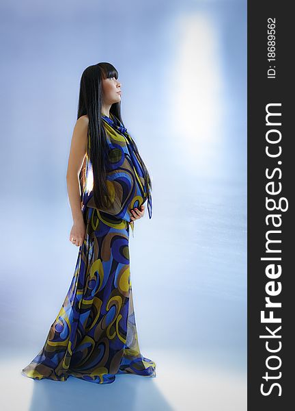 Asian pregnant woman in transparent dress on blue background with radiance. Asian pregnant woman in transparent dress on blue background with radiance