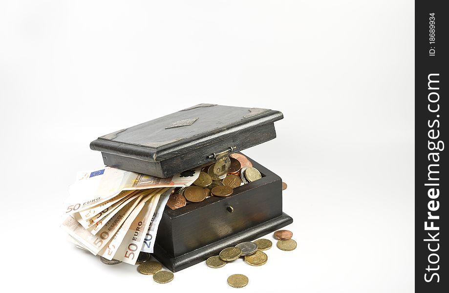 Photo of an old box full with coins and banknotes