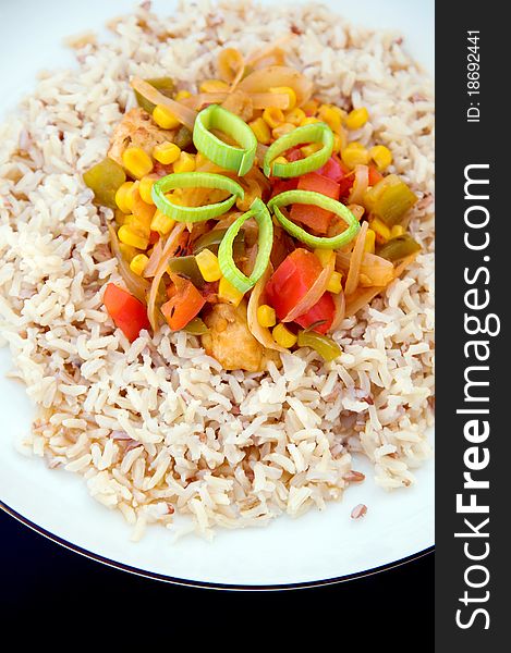 Appetizing rice dish on white plate on black background