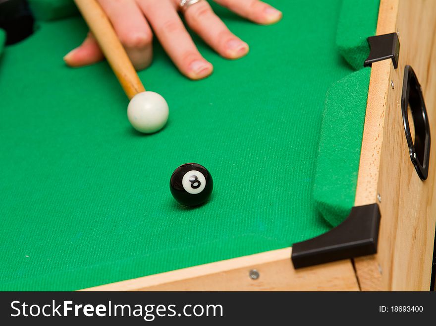 Small green billiard (poool) table with white and black ball