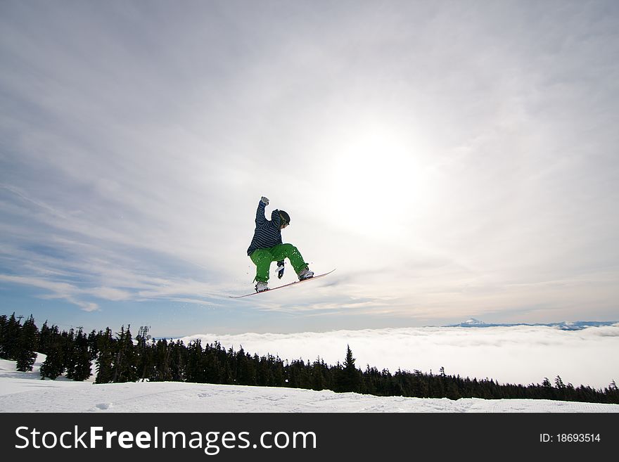 Male Snowboarder Catches Big Air on a Bright Sunny Day. Male Snowboarder Catches Big Air on a Bright Sunny Day.