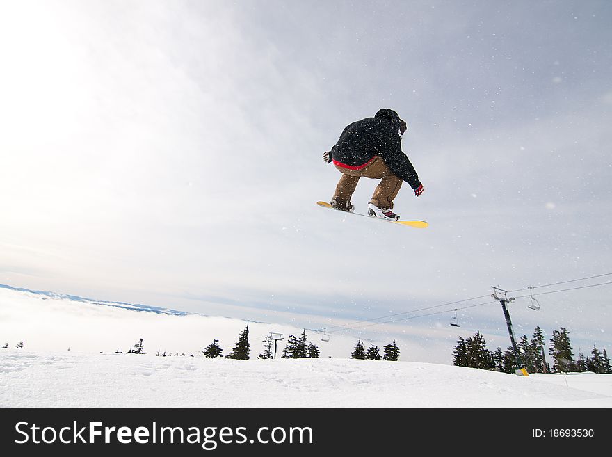 Male Snowboarder Catches Big Air on a Bright Sunny Day. Male Snowboarder Catches Big Air on a Bright Sunny Day.