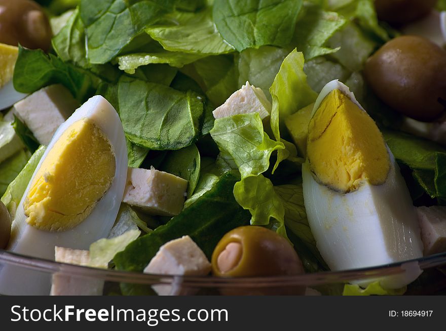 Romain Lettuce, Spinach,Tofu, Eggs and Green Olives in a Glass Bowl. Romain Lettuce, Spinach,Tofu, Eggs and Green Olives in a Glass Bowl