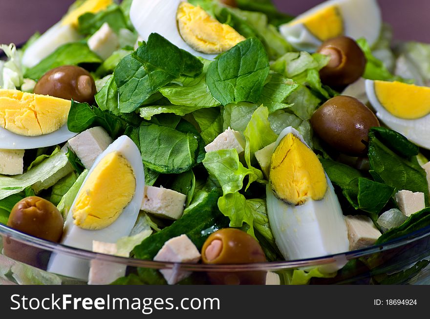 Romain Lettuce, Spinach, Tofu, Eggs and Green Olives in a Glass Bowl. Romain Lettuce, Spinach, Tofu, Eggs and Green Olives in a Glass Bowl